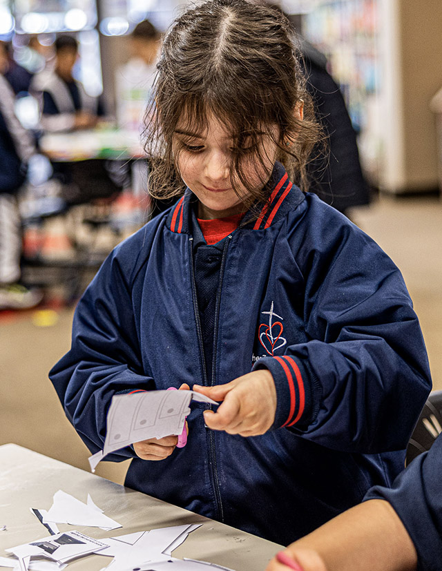 Student cutting paper at Mother Teresa Catholic Primary School Westmead
