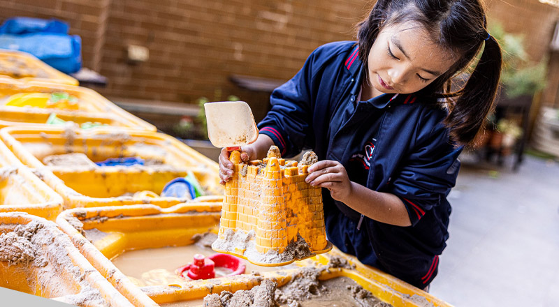 Student making sand castles at Mother Teresa Catholic Primary School Westmead