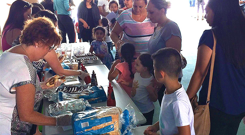 Parents helping at fundraiser barbeque at Mother Teresa Catholic Primary School Westmead