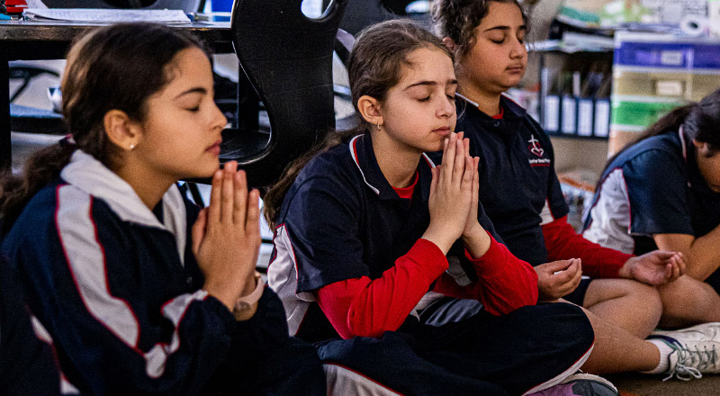 Students praying at Mother Teresa Catholic Primary School Westmead