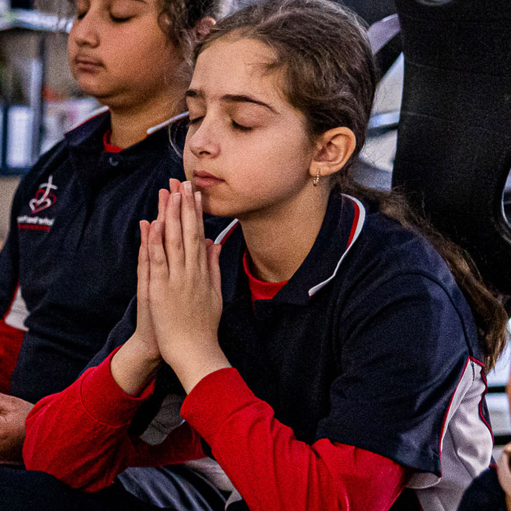 Student praying at Mother Teresa Catholic Primary School Westmead